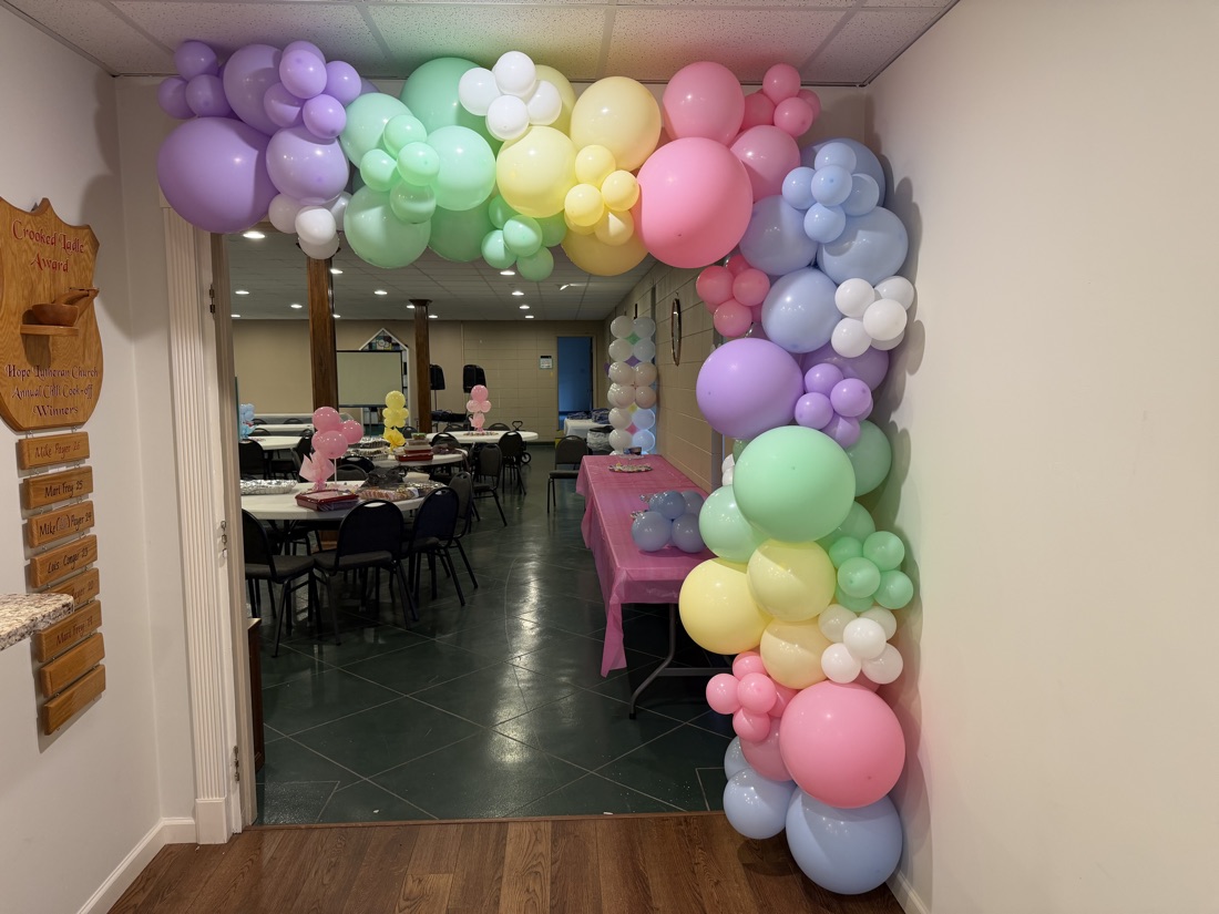 Pastel rainbow balloon arch in a doorway