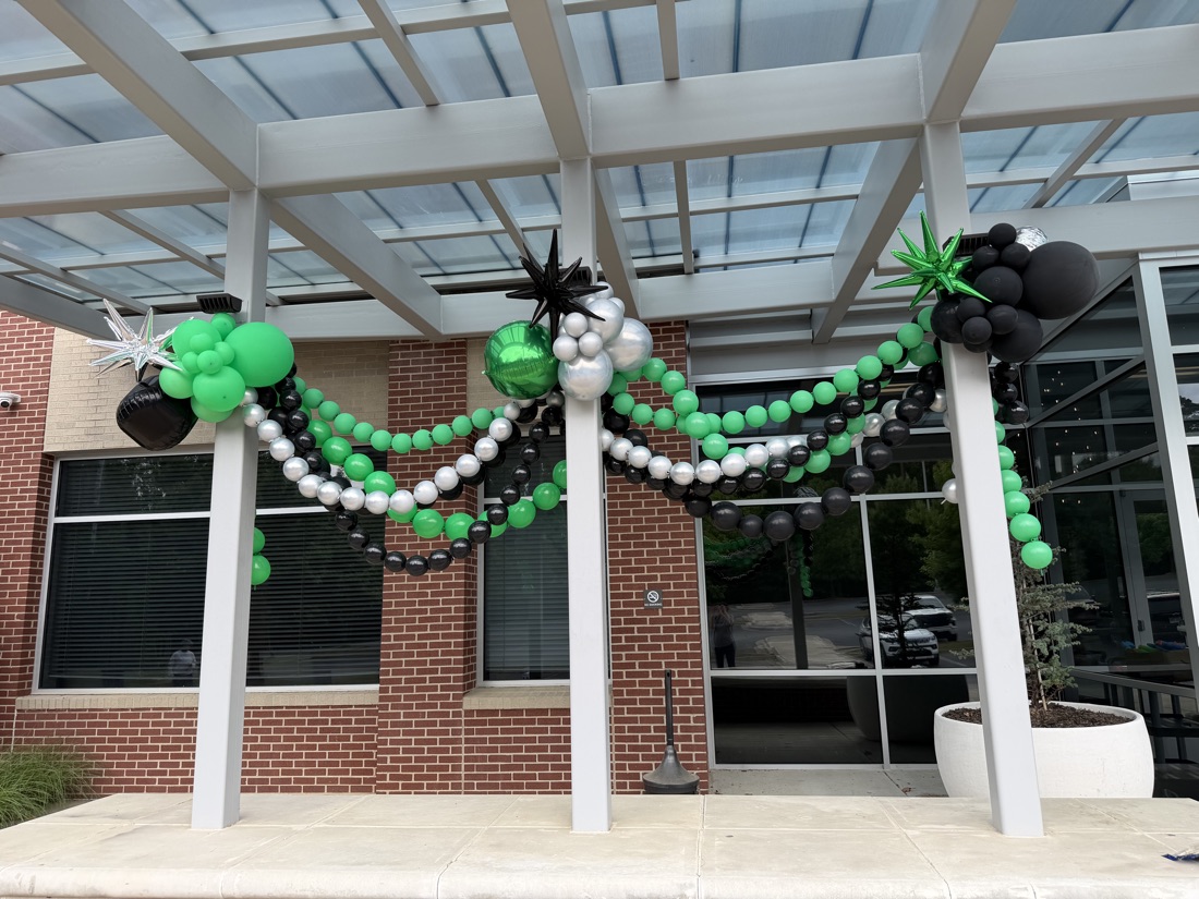 Balloon garland draped across outdoor rafters