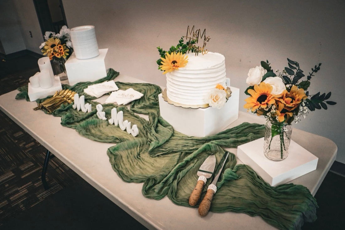 Wedding cake table with sage runner and florals